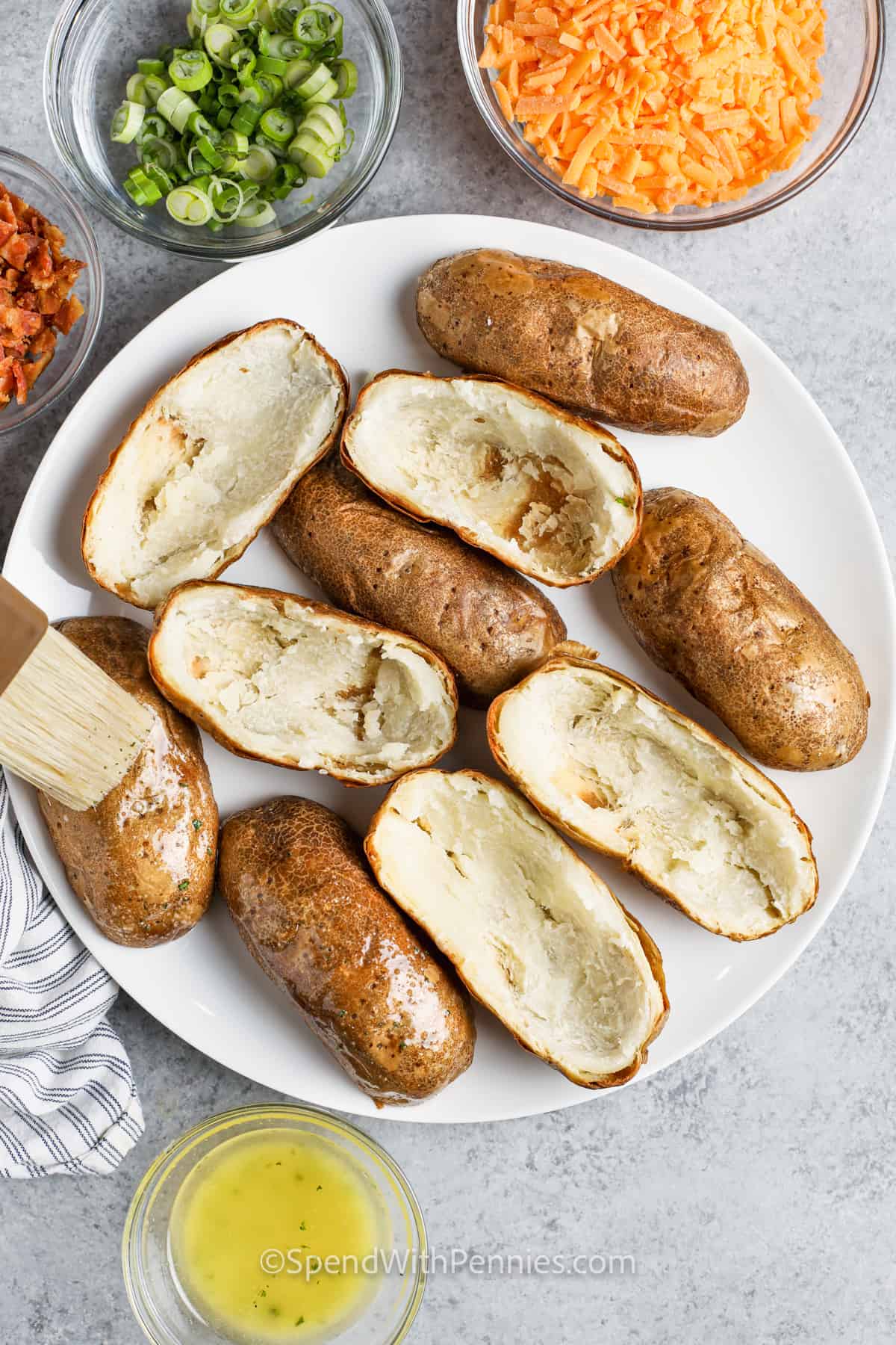 brusing butter over potatoes to make Crispy Oven Baked Potato Skins