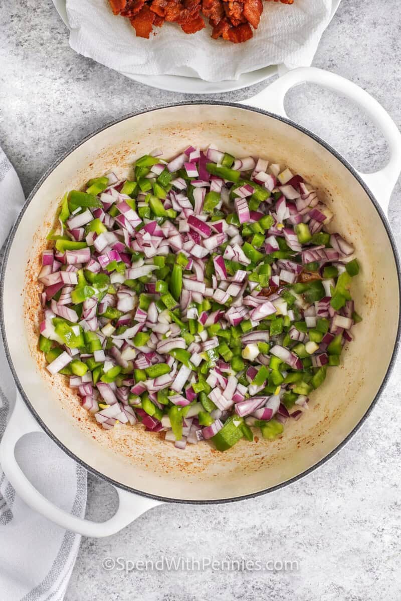 adding onions and peppers to the pot to make The Best Baked Beans