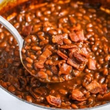 taking a spoonfull of The Best Baked Beans out of the pot