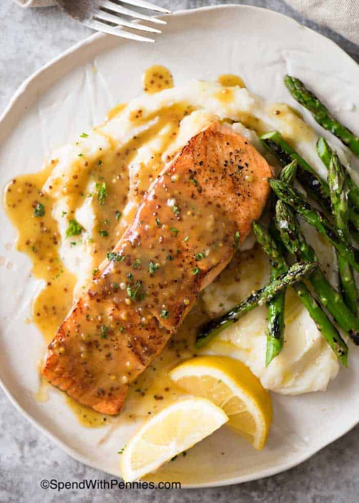 Honey Mustard Salmon on a plate with lemon and asparagus