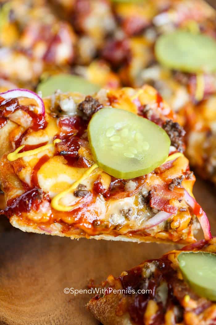 a slice of Cheeseburger Pizza topped with pickles