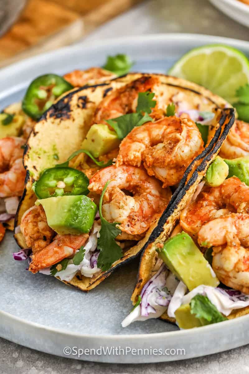 shrimp tacos topped with jalapenos, avocados, and cilantro