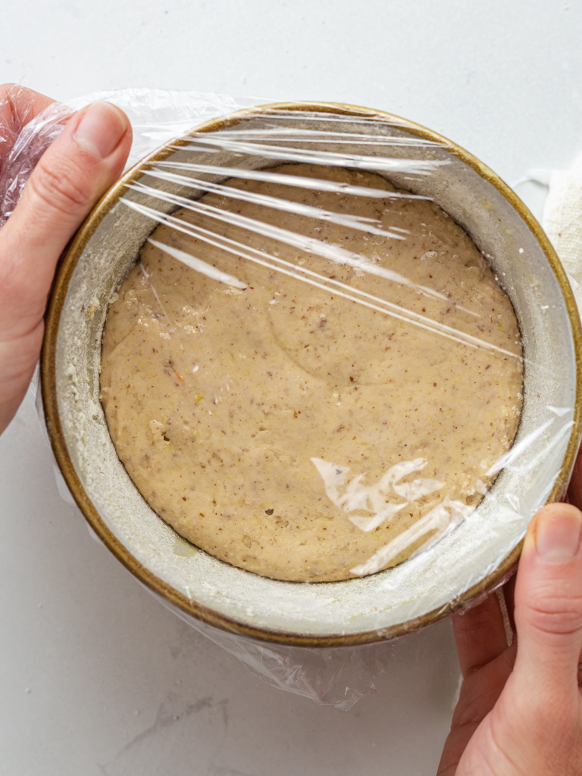 lentil bread dough proving in a bowl covered with cling film