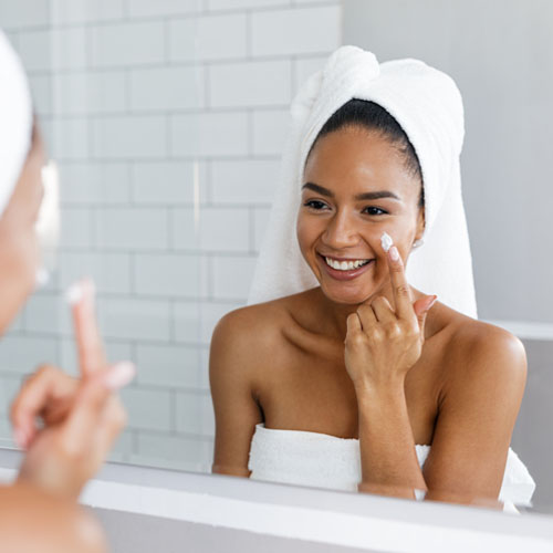 woman putting on face cream