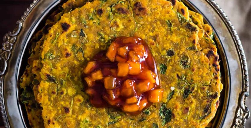 Methi thepla served in a metal plate with chundo on top